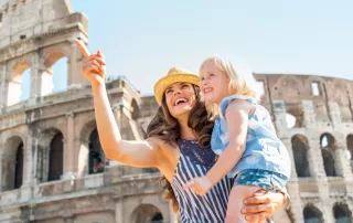 a woman with her daughter in front of the Colosseum in Rome, Italy