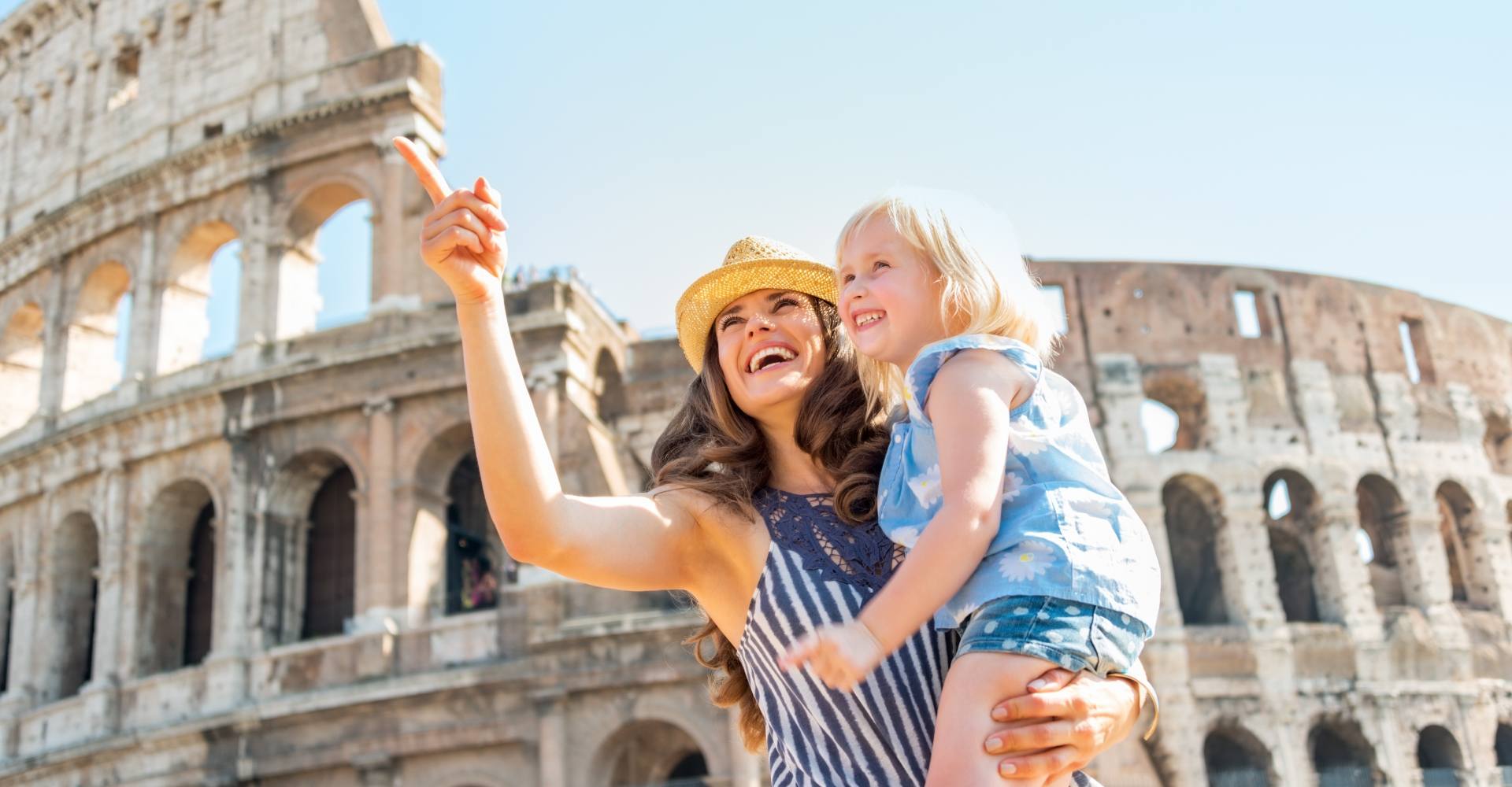 a woman with her daughter in front of the Colosseum in Rome, Italy